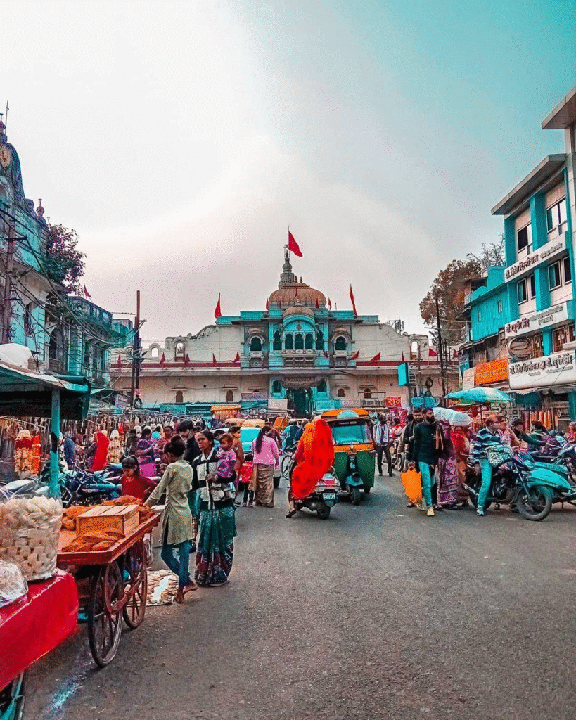 Old city street market in Ujjain with shops and cows