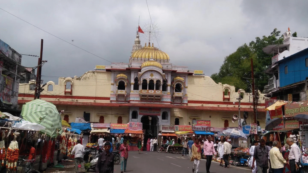 Old city street market in Ujjain with shops and cows
