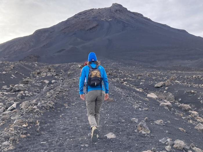 Hikers climbing the black volcanic gravel path up Fogo volcano, Cape Verde